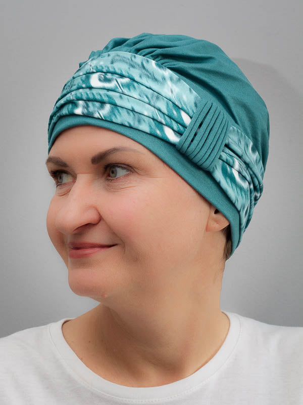 Soft bamboo green hat with a vibrant, colorful band for chemo and alopecia patients