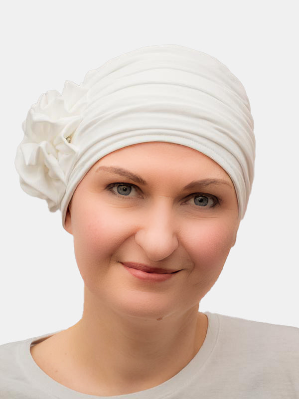 Soft bamboo head gear with flower, designed for sensitive scalps during chemo and alopecia